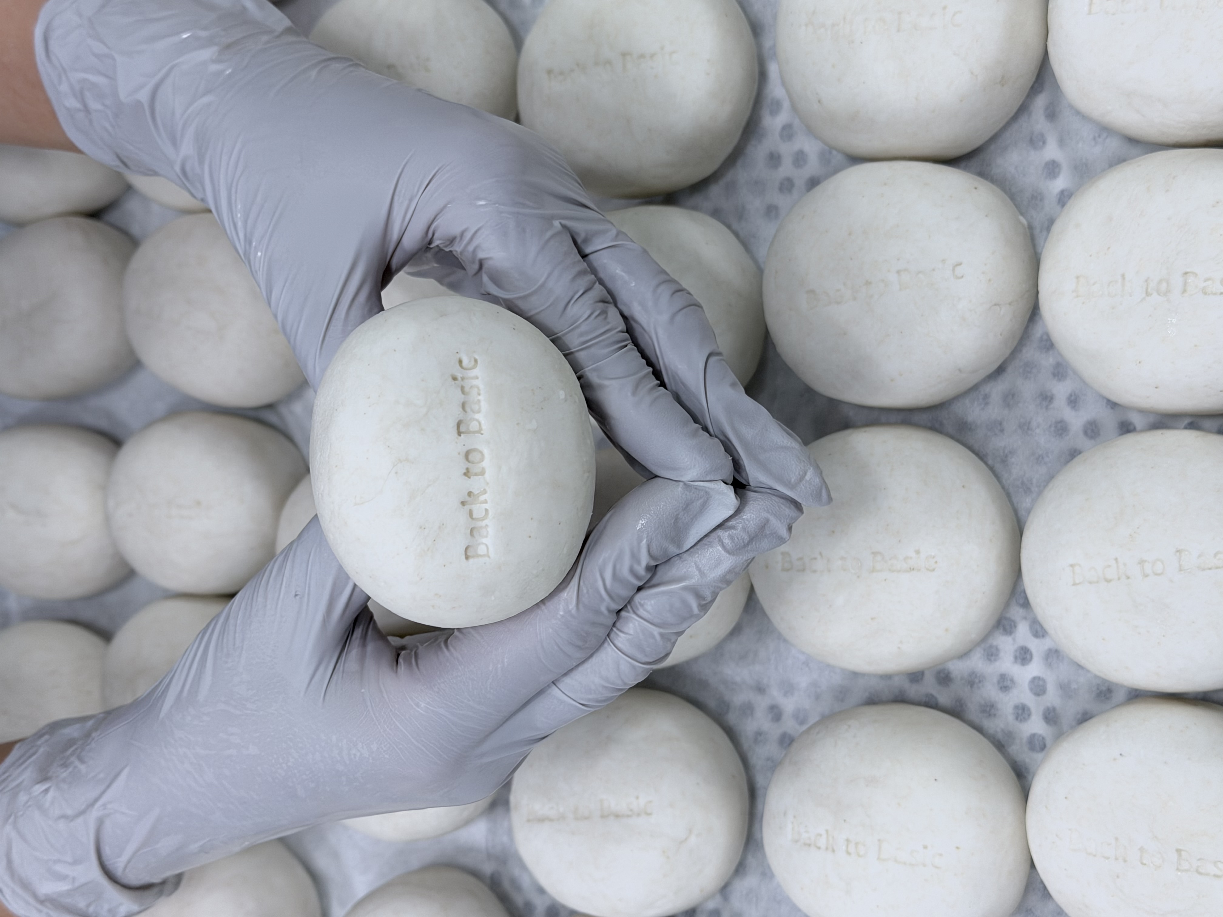 Hands holding ARA bar with Back to Basic stamp — quality inspection